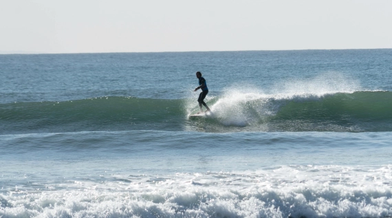 Guide 2026 : Top 5 des spots de Kitesurf à Dakhla Surfeur sur une vague longue et régulière au spot de Foum Labouir à Dakhla.